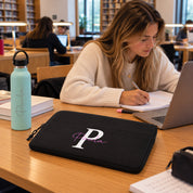 Funda de portátil Boston negra personalizada con inicial y nombre, chica estudiando en la biblioteca