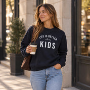 Sudadera azul marino personalizada "Life is better with my kids" para mamá, mujer paseando por la ciudad con un café